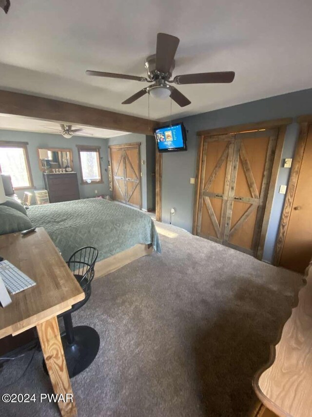 carpeted bedroom featuring beamed ceiling and ceiling fan