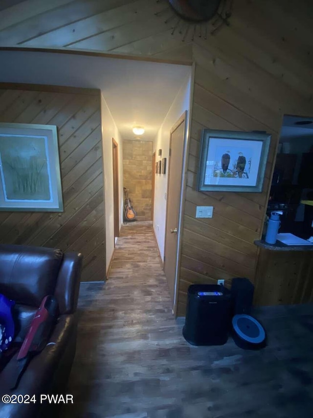 corridor with hardwood / wood-style flooring and wooden walls