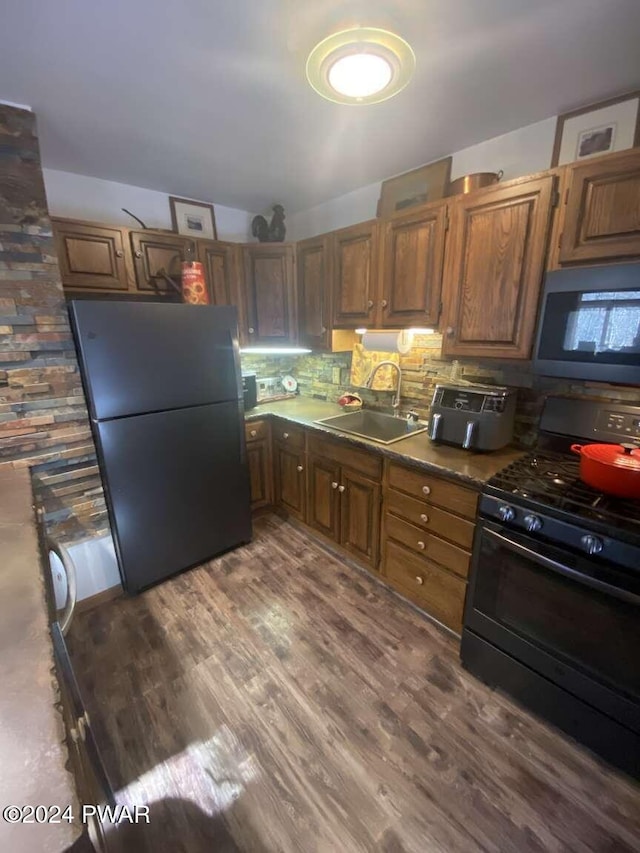 kitchen with backsplash, refrigerator, sink, gas stove, and dark hardwood / wood-style flooring