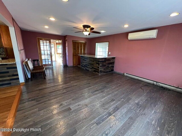 unfurnished living room with an AC wall unit, ceiling fan, and dark hardwood / wood-style floors