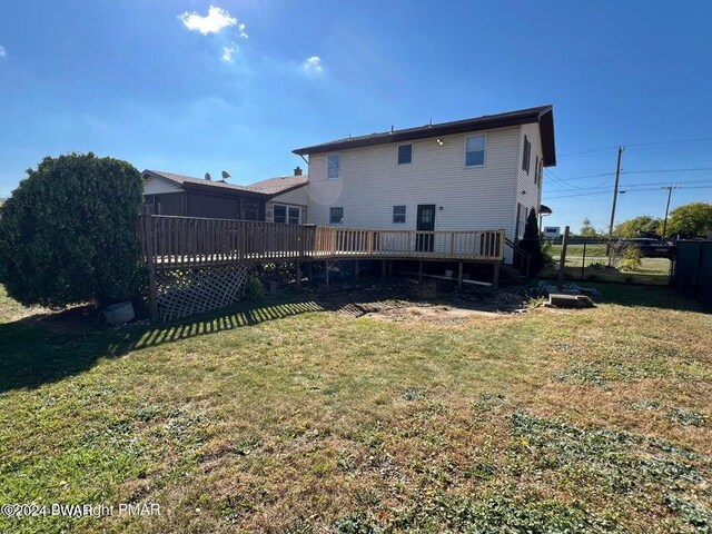 rear view of property featuring a deck and a lawn