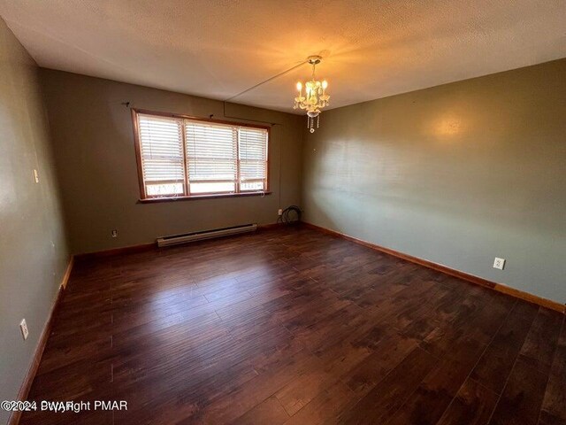 spare room featuring a textured ceiling, dark hardwood / wood-style flooring, a baseboard radiator, and a notable chandelier