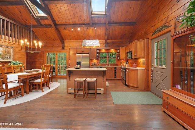 kitchen with appliances with stainless steel finishes, a skylight, baseboard heating, and pendant lighting