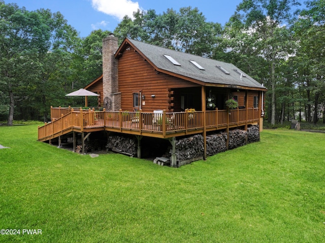 rear view of house featuring a lawn and a wooden deck