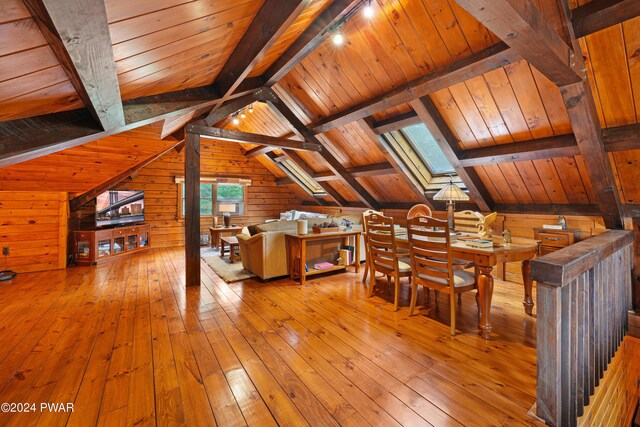 interior space with light hardwood / wood-style floors, lofted ceiling with skylight, wooden ceiling, and wood walls