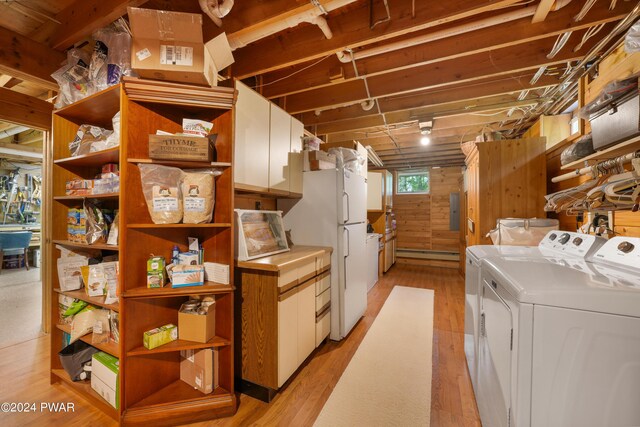 basement featuring light wood-type flooring, white fridge, washer and clothes dryer, and a baseboard heating unit