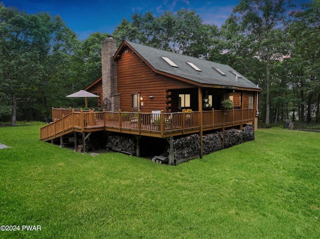 back house at dusk featuring a yard and a wooden deck