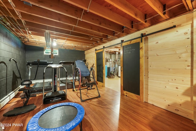 workout room featuring wood-type flooring and a barn door