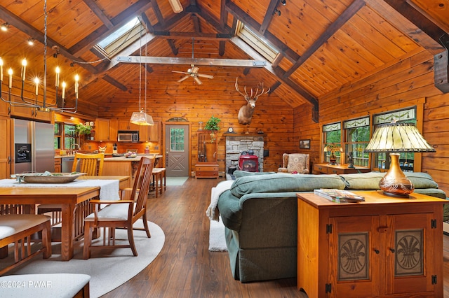 living room with a skylight, wood walls, beamed ceiling, and hardwood / wood-style flooring