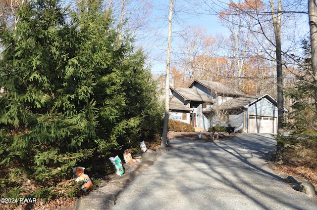 view of property hidden behind natural elements with a garage