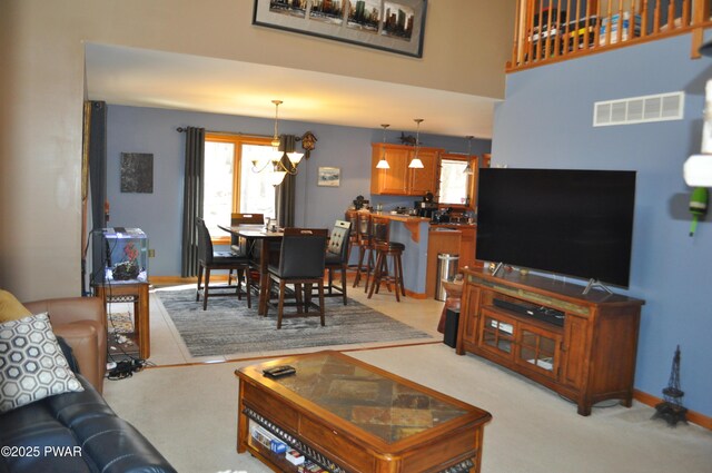 living room with a stone fireplace, light carpet, and lofted ceiling