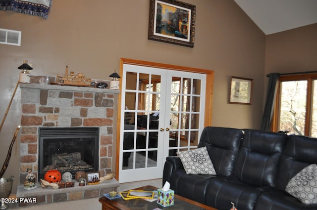 living room with carpet flooring, lofted ceiling, a fireplace, and french doors