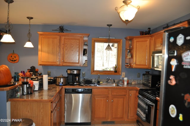 kitchen featuring pendant lighting, stainless steel appliances, and sink