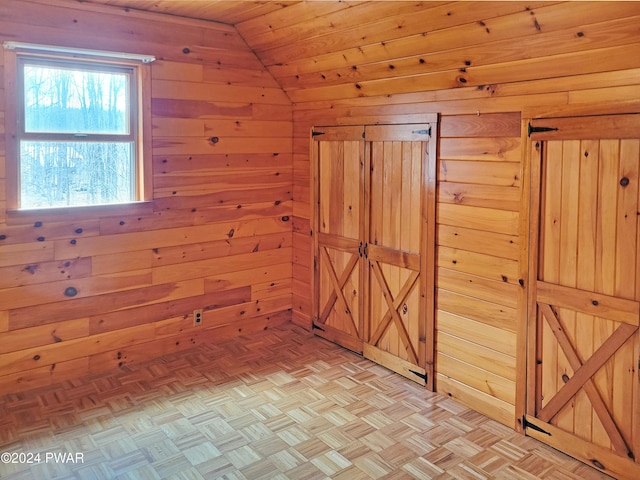 interior space with wooden ceiling, lofted ceiling, wooden walls, and light parquet flooring