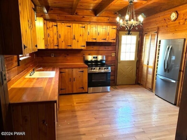 kitchen with beam ceiling, sink, hanging light fixtures, a notable chandelier, and appliances with stainless steel finishes