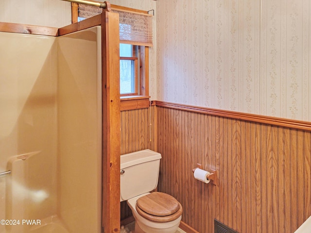 bathroom with toilet and wooden walls