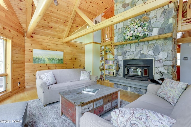 33 Syloro Ln, Damascus, PA 18415 - living area with wood finished floors, plenty of natural light, wood ceiling with exposed beams, wooden walls, and a wood stove