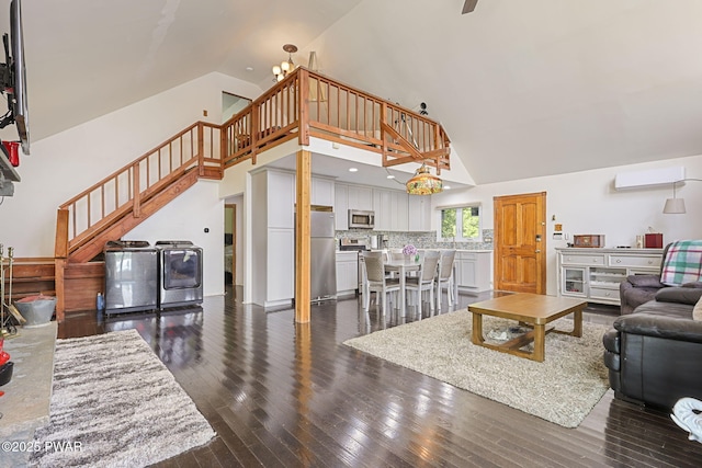 18 Tammany Flts, Damascus, PA 18415 - living room with high vaulted ceiling, stairway, washing machine and dryer, a wall mounted air conditioner, and dark wood-style floors