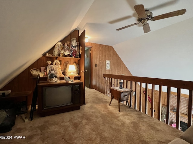 additional living space with carpet, ceiling fan, wooden walls, and vaulted ceiling