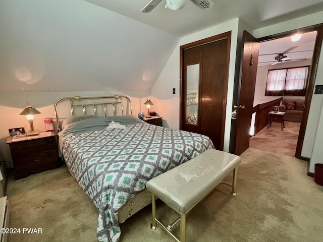 carpeted bedroom with ceiling fan, a closet, and vaulted ceiling