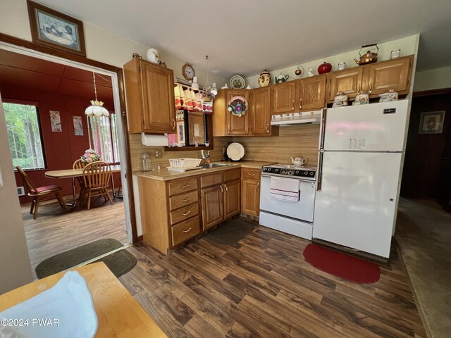 kitchen with sink, dark hardwood / wood-style flooring, white appliances, and backsplash