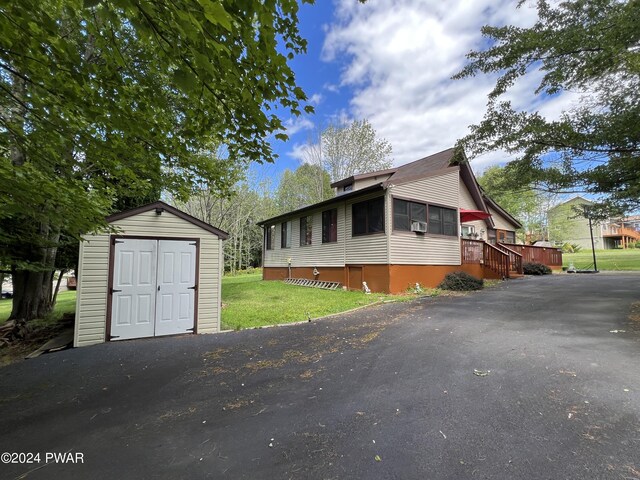 view of front of property featuring a front yard and a shed