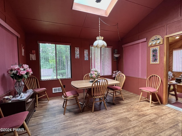 dining area featuring a skylight and hardwood / wood-style floors