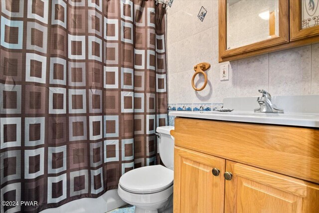 bathroom with backsplash, vanity, a shower with shower curtain, and toilet