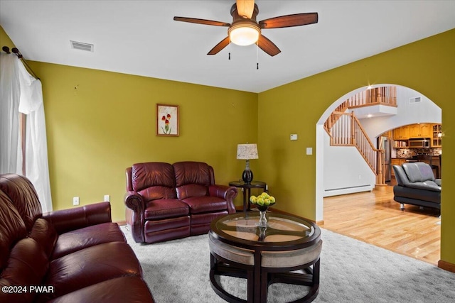 living room featuring ceiling fan, carpet floors, and a baseboard radiator