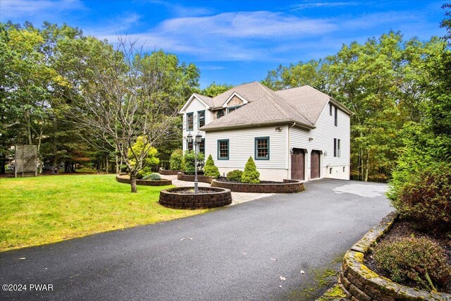 view of front of home featuring a front yard and a garage