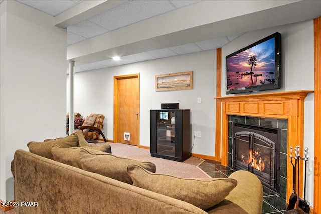 living room with a tiled fireplace and a drop ceiling