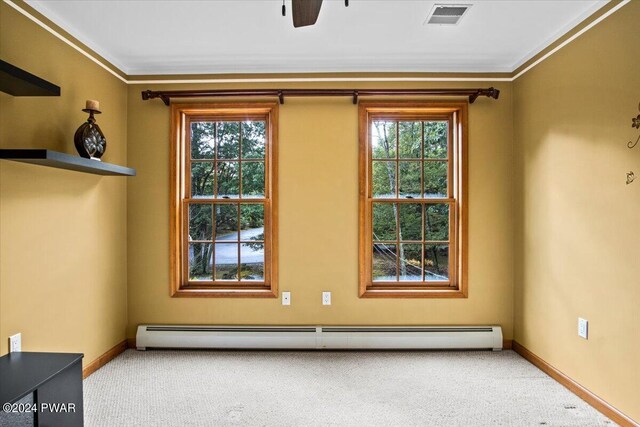 carpeted spare room with ornamental molding, ceiling fan, and a baseboard heating unit