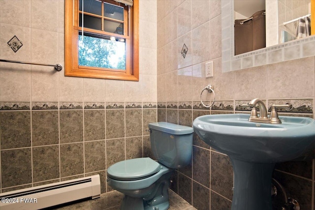 bathroom featuring baseboard heating, tile walls, and toilet