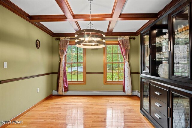 empty room featuring coffered ceiling, light hardwood / wood-style flooring, a baseboard radiator, beam ceiling, and a chandelier