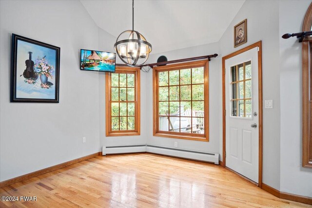 interior space featuring a notable chandelier, light hardwood / wood-style flooring, and vaulted ceiling