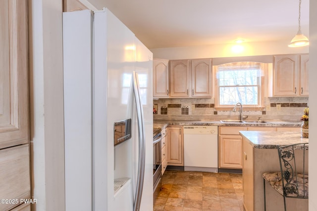 kitchen featuring white appliances, light brown cabinets, a sink, and decorative backsplash