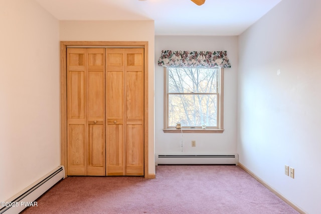 unfurnished bedroom featuring carpet floors, a baseboard radiator, a closet, and a ceiling fan