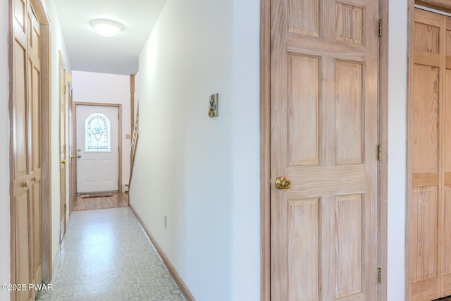 hallway featuring tile patterned floors and baseboards