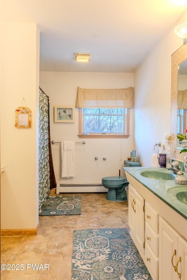 bathroom with double vanity, a sink, and baseboards