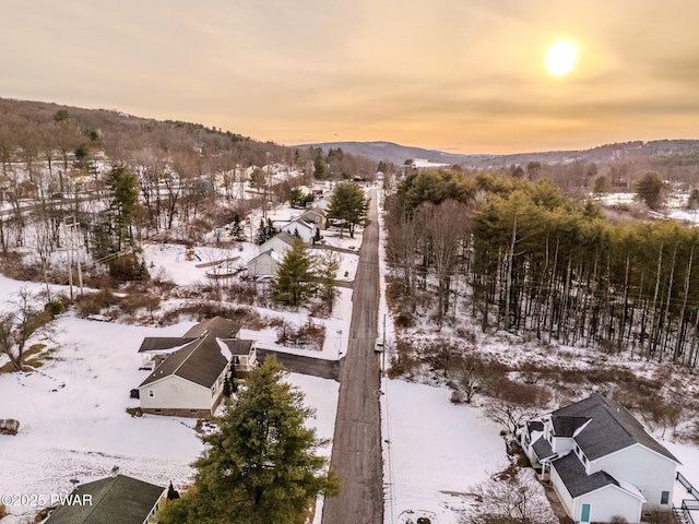 snowy aerial view featuring a residential view and a mountain view