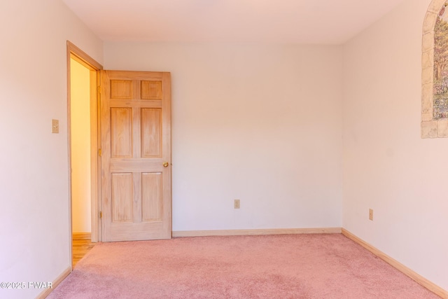 unfurnished room with carpet flooring and baseboards