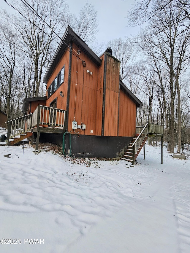 snow covered property with a wooden deck