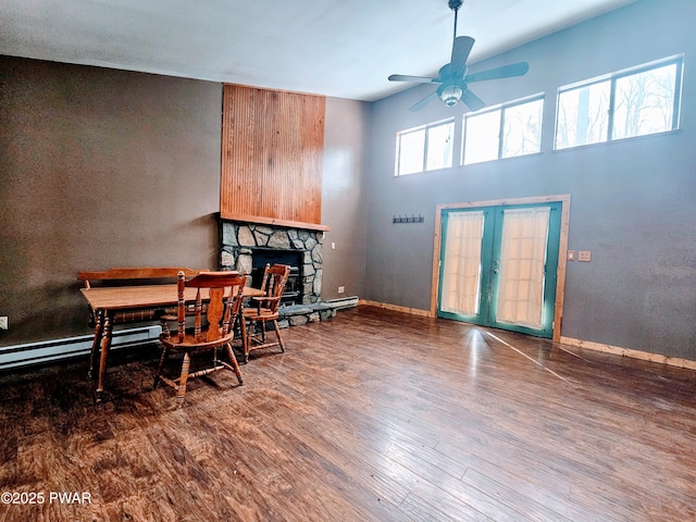 dining room with hardwood / wood-style flooring, a fireplace, french doors, and ceiling fan