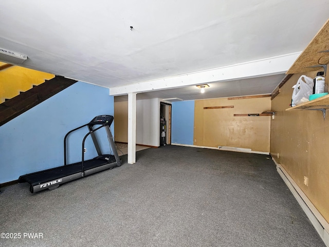 exercise room featuring a baseboard heating unit and dark colored carpet