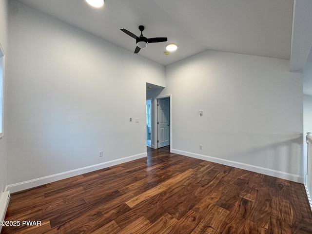 spare room with a ceiling fan, dark wood-style floors, baseboards, and high vaulted ceiling