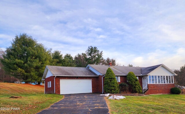 ranch-style home featuring a garage and a front lawn