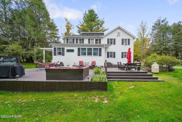 back of house featuring outdoor lounge area, a deck, and a lawn