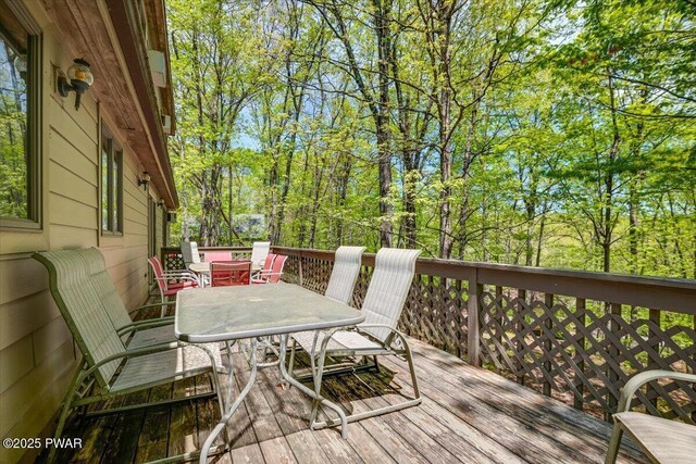 146 Cove Point Cir, Lakeville, PA 18438 - wooden deck featuring outdoor dining space and view of scattered trees