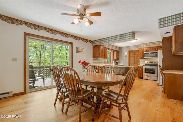 146 Cove Point Cir, Lakeville, PA 18438 - dining space featuring a textured ceiling, light wood-style flooring, a ceiling fan, baseboards, and baseboard heating