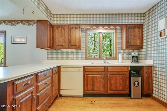 146 Cove Point Cir, Lakeville, PA 18438 - kitchen featuring dishwasher, a sink, wallpapered walls, light wood-style flooring, and brown cabinets